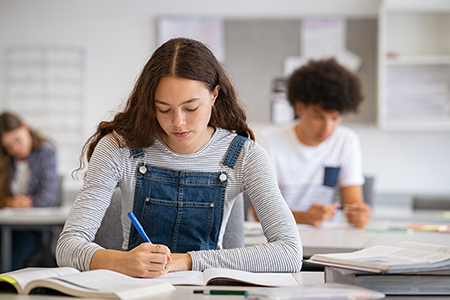College girl studying with concentration in class