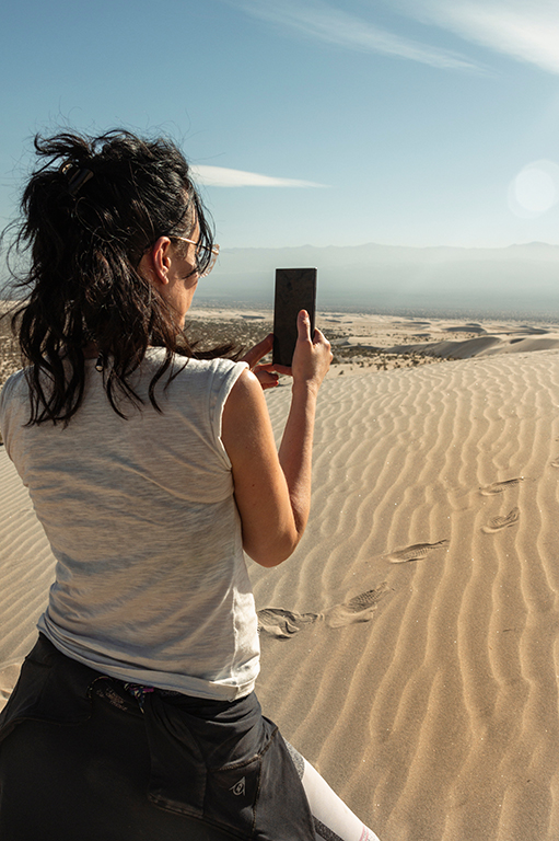young woman with a mobile phone on the dune